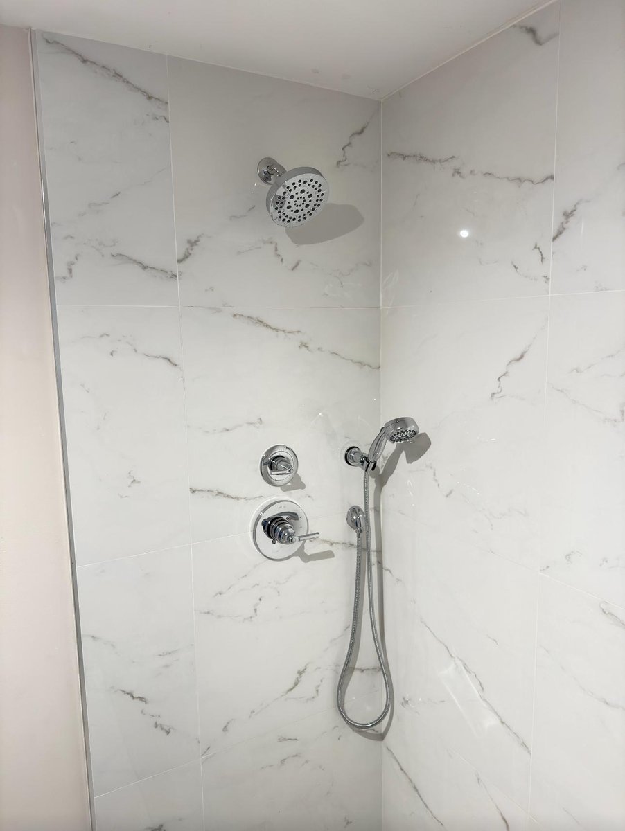 Gold freestanding tub faucet installed on marble wall