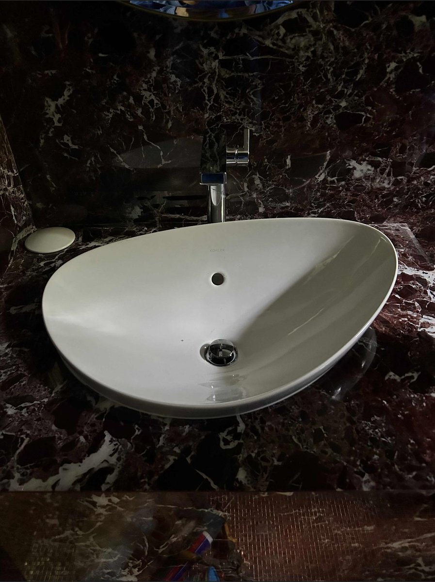 Standard toilet installed over gray tile floor